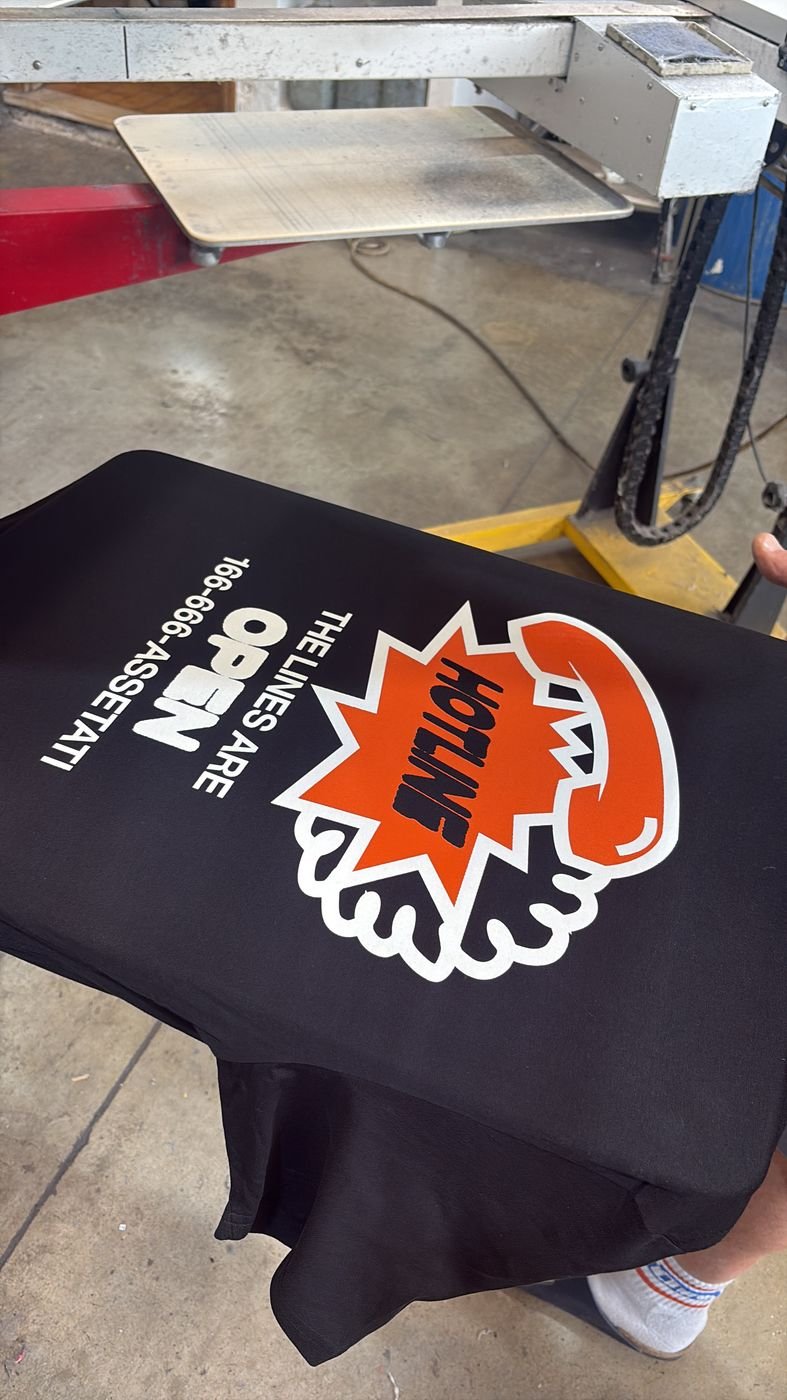 Una t-shirt nera appena stampata sotto la giostra serigrafica